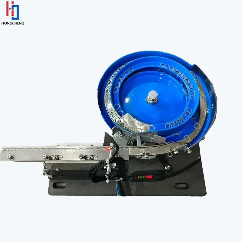 Blue-lined bowl feeder with ring-shaped components and a linear outfeed track.