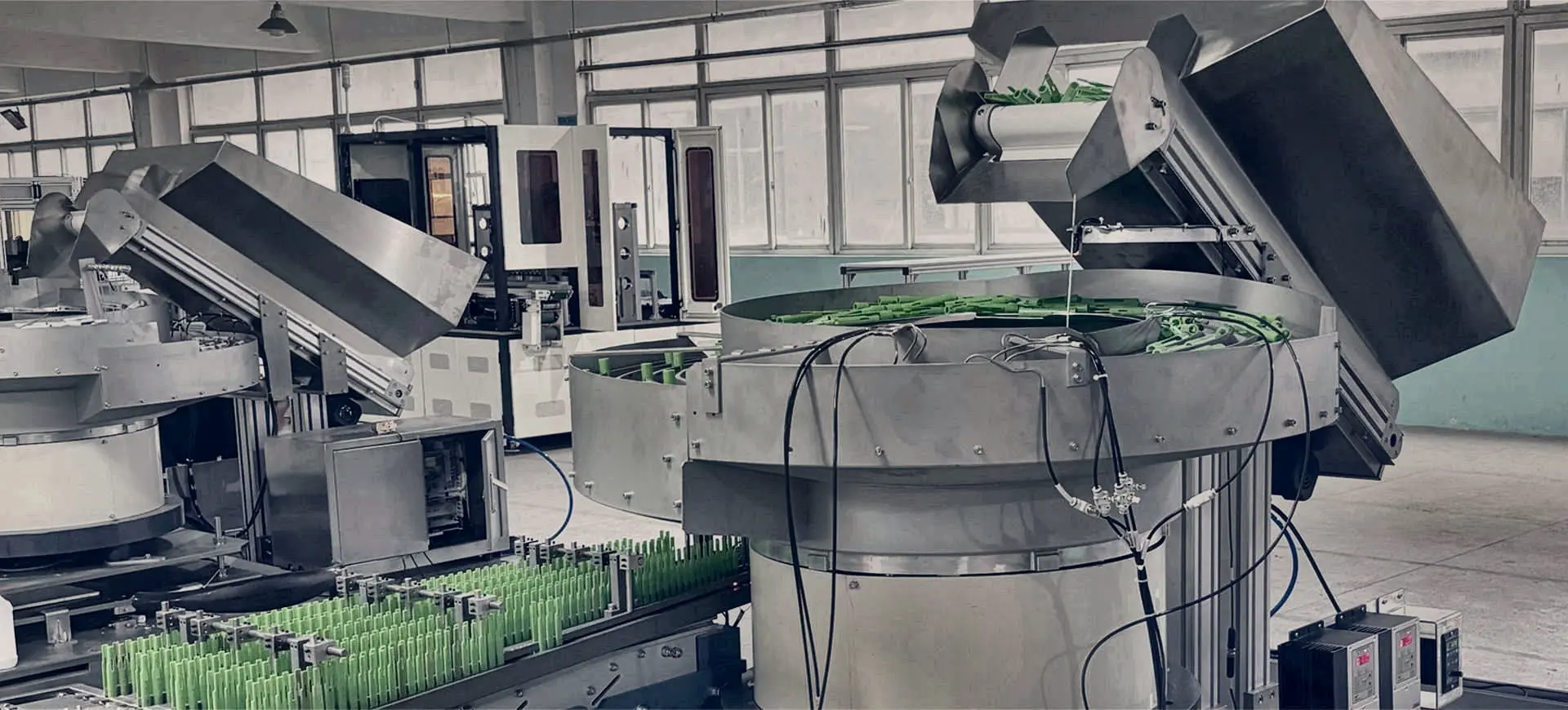 Bowl feeders and hopper elevators with green components on the feeding line.